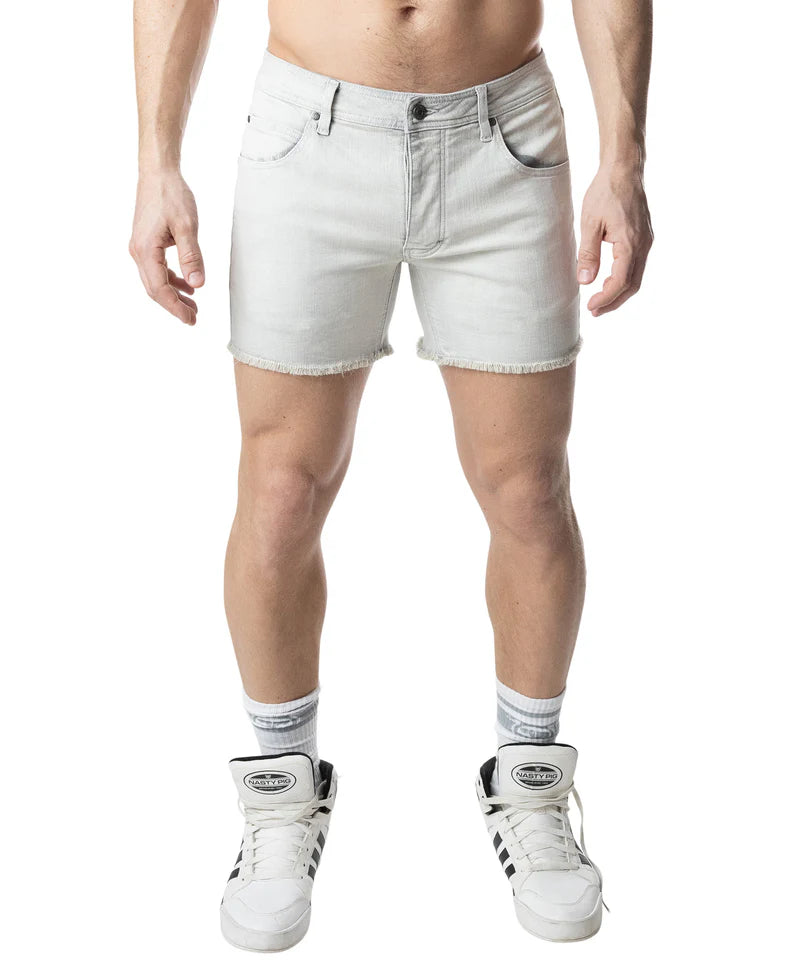 Person wearing light-colored denim shorts and white sneakers on a white background